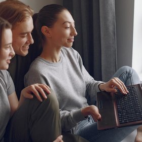 friends-sitting-bed-room-use-laptop