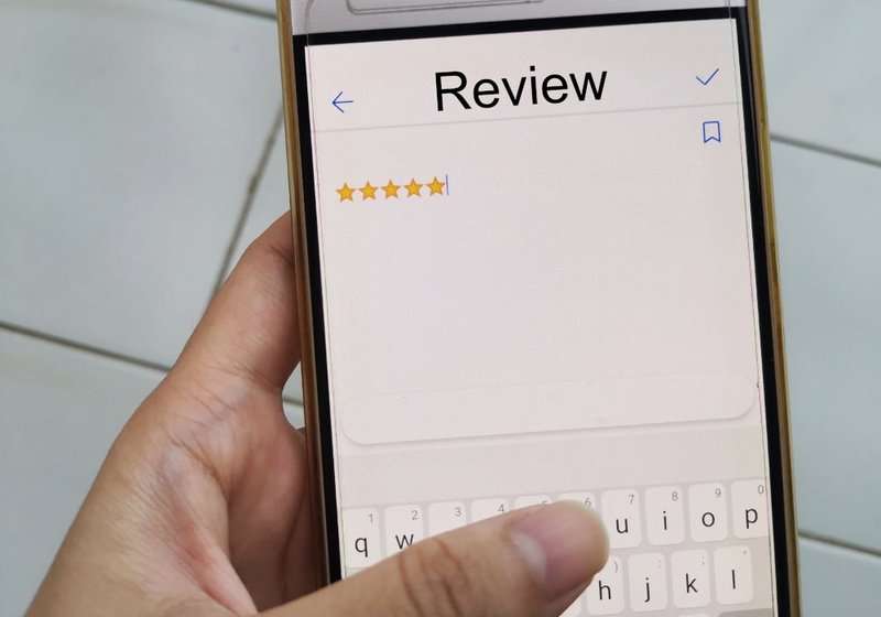 Customer hands holding a smartphone, submitting a review